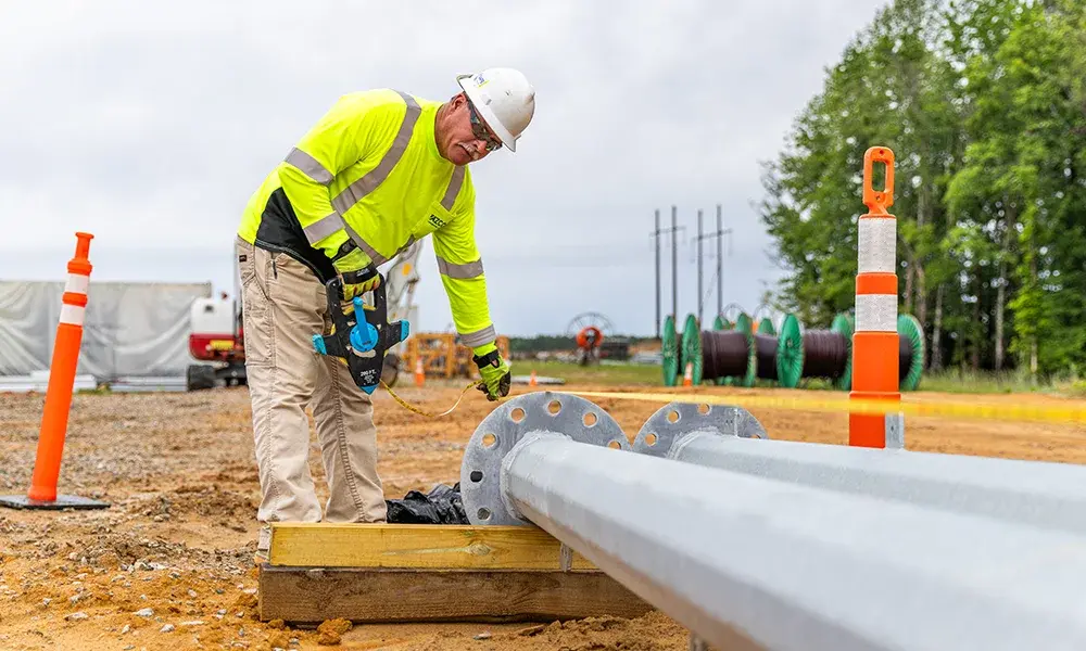construction worker measuring pole bases